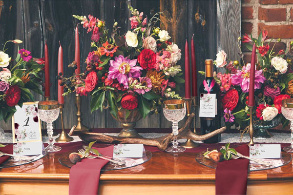 dekoracje stołu weselnego z motywem burgundowych kwiatów